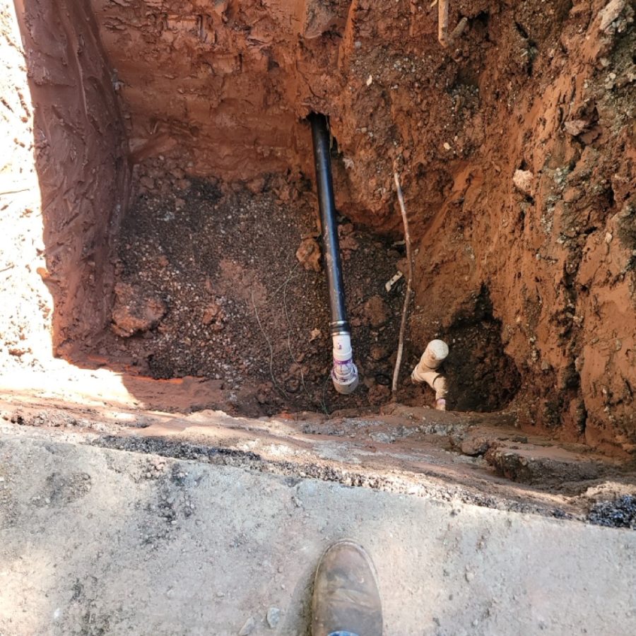 Open excavation at a sewer lateral showing trench depth